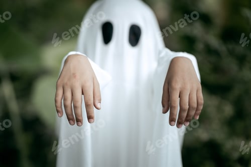 Preview: A young boy dressed as a ghost for Halloween wears a white sheet with two black eye holes