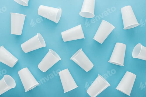 Preview: top view of white and plastic cups on blue background