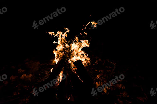 Preview: logs burning in camp fire in darkness