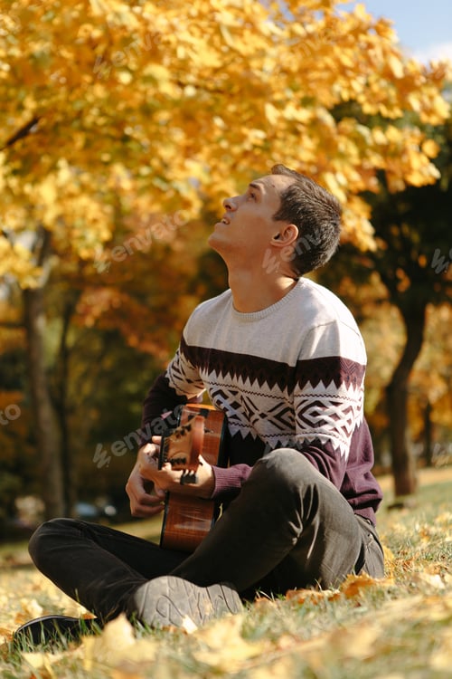 Preview: Handsome Guy With Guitar In The Autumn Park