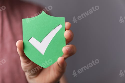 Preview: Sign of the checkmark made of paper in the hands of a man