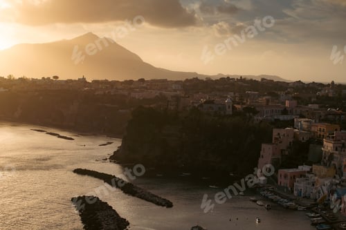 Preview: Houses of Procida in magic sunset with the island of Ischia in the background.