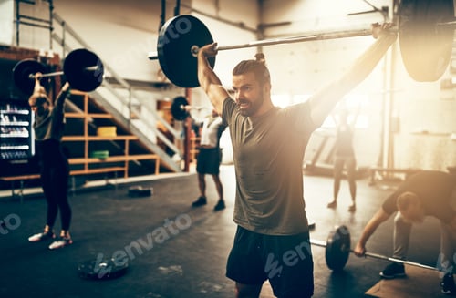 Preview: Fit young man weight training in a gym class