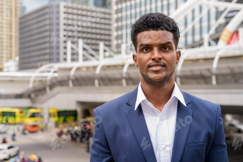 Preview: Portrait of African businessman looking at camera while in city