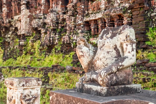 Preview: Stone statue of a headless man in front of a temple with green moss. My Son, Vietnam.