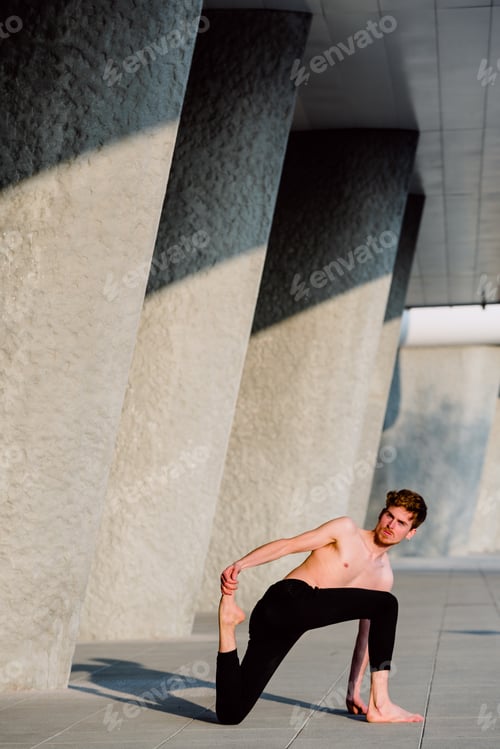 Preview: Young male runner performing leg stretches outdoors to gain flexibility.