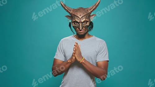 Preview: Young man wearing ancient tribal mask with sacral pattern