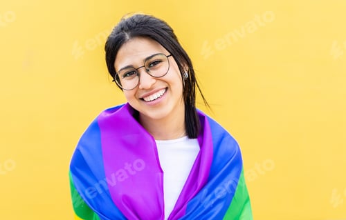 Preview: Portrait of young lesbian woman smiling at camera over yellow background