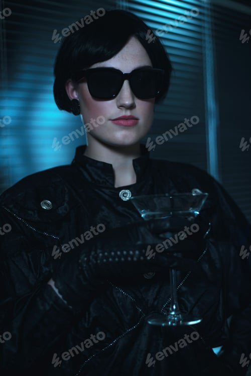 Preview: Retro 80S Woman In Black Sunglasses And Dress Holding Cocktail Glass.