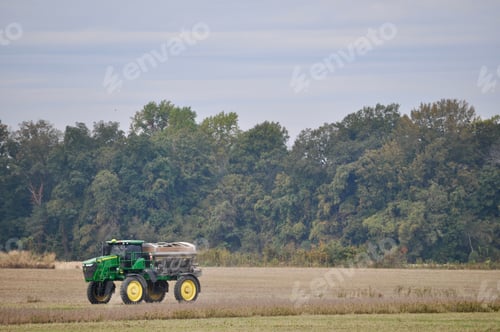 Preview: Farmer working on the farm riding his tractor in the field.
