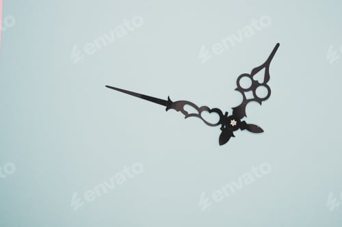 Preview: High angle shot of a pair of clock hands on a blue surface