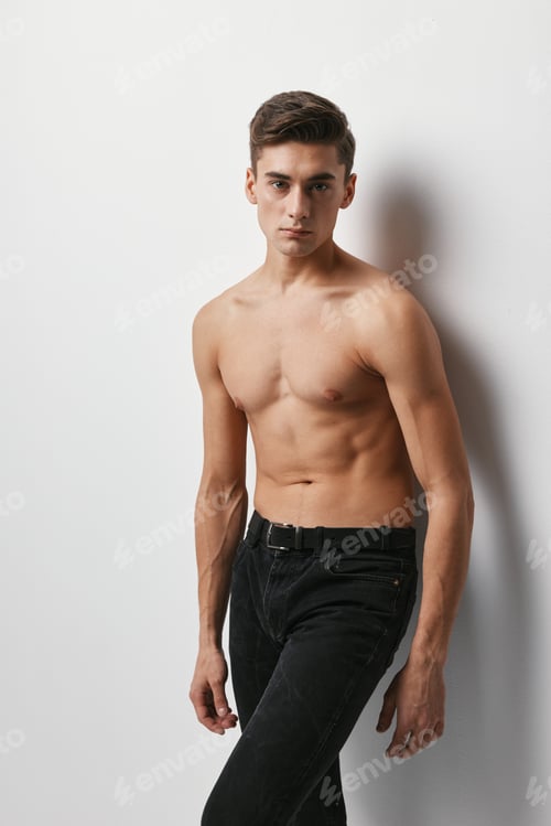 Preview: Handsome guy nude torso black pants light background model