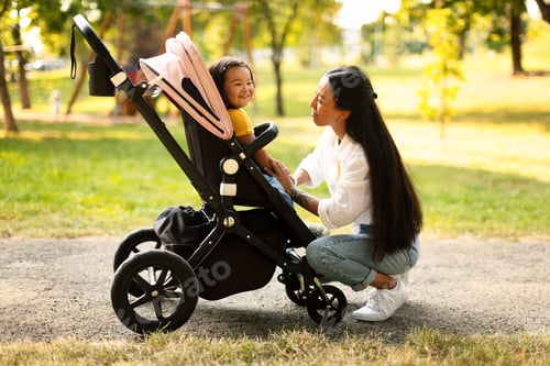 Preview: Cheerful Asian Mommy Talking To Toddler Daughter In Stroller Outdoor