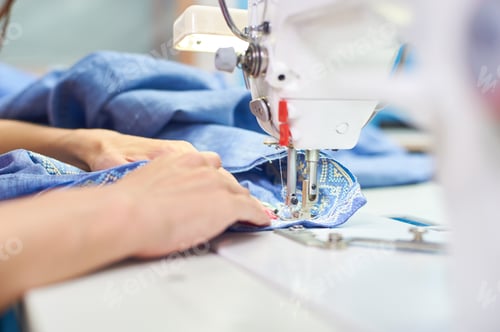 Preview: Industrial sewing machine and hand seamstress. Close-up