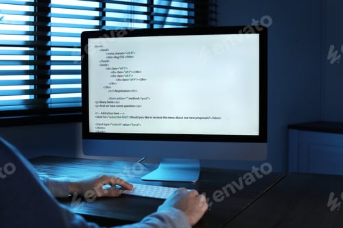 Preview: Man using computer in dark room, closeup. Criminal offence