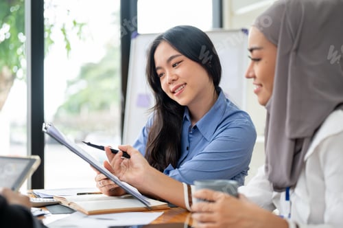 Preview: A beautiful Asian businesswoman is listening to her Muslim colleague's ideas for a project