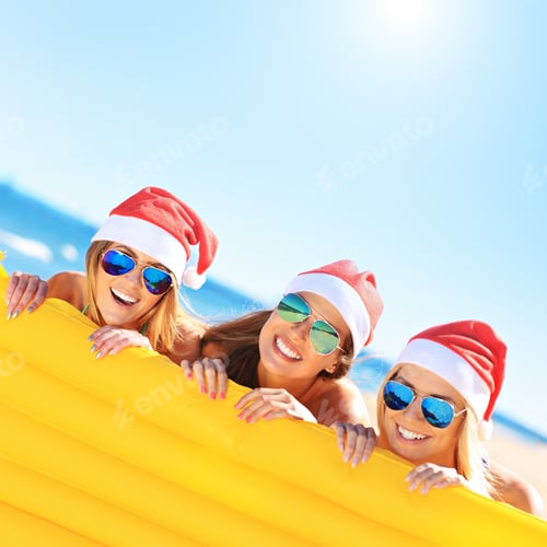 Preview: Group of girls in Santa's hats having fun on the beach