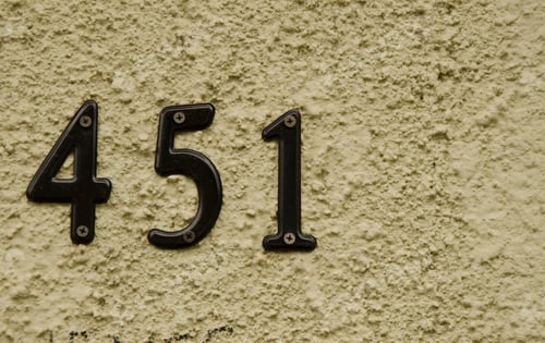 Preview: Closeup of an address number 451 on the rough surface of a wall