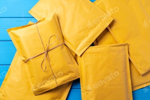 Preview: Lot of yellow paper postal envelopes. Top view.
