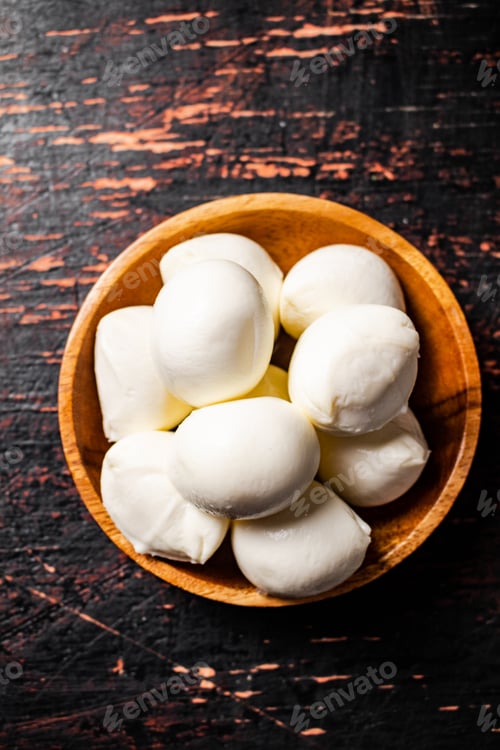 Preview: A wooden plate on a table with mozzarella.