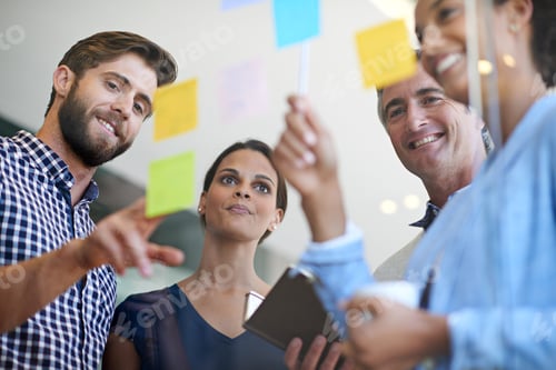 Preview: Shot of coworkers arranging sticky notes on a glass wall during a brainstorming session