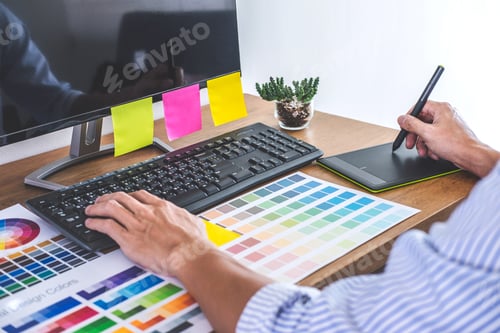Preview: Image of male creative graphic designer working on color selection and drawing on graphics tablet at