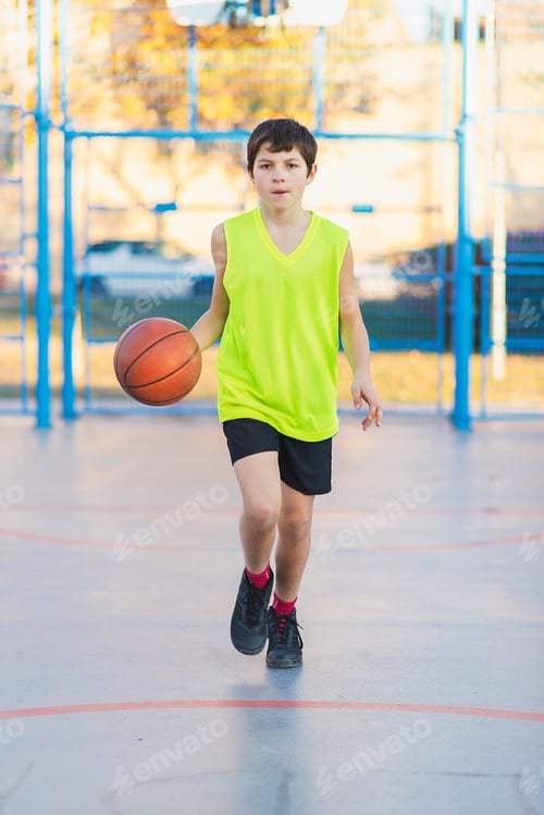 Preview: Teenager playing basketball on an outdoors court