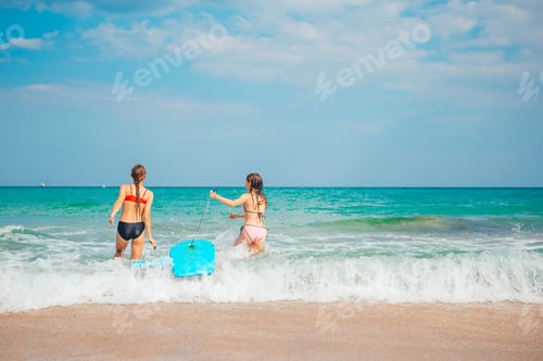 Preview: Adorable little girls have fun on the beach swimming and splashing