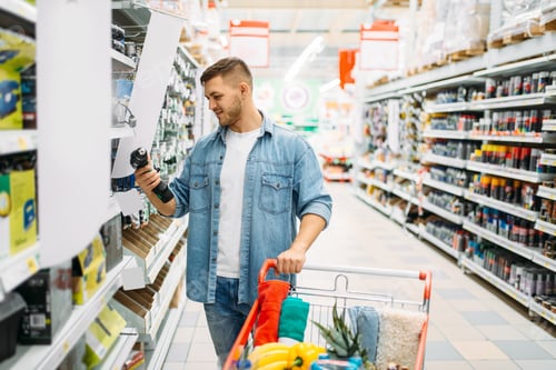 Preview: Man choosing electric screwdriver in supermarket