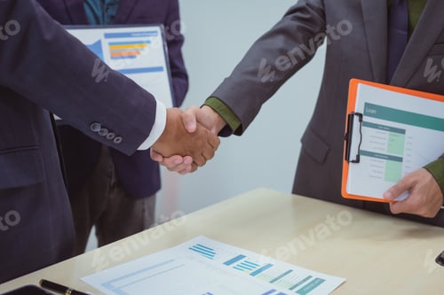 Preview: Close-up of business people shaking hands during meeting in the office,discussing analyzing charts