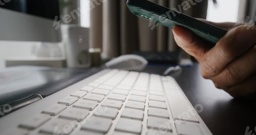 Preview: Man use cellphone flashlight to check on keyboard