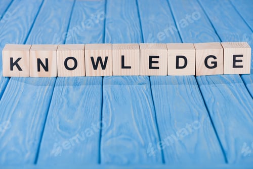 Preview: close up view of knowledge word made of wooden blocks on blue tabletop