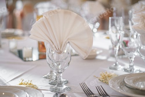 Preview: Closeup shot of a glass with a folded cloth on a wedding table