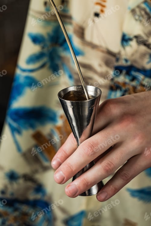 Preview: Close-up of bartender pouring alcohol into a jigger