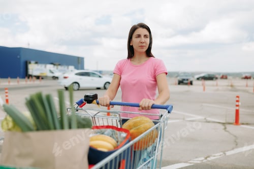 Preview: woman with a Shopping Cart in the Supermarket Parking Lot