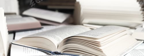 Preview: stack of books, close up. Open book on the table in library. Back to school concept.