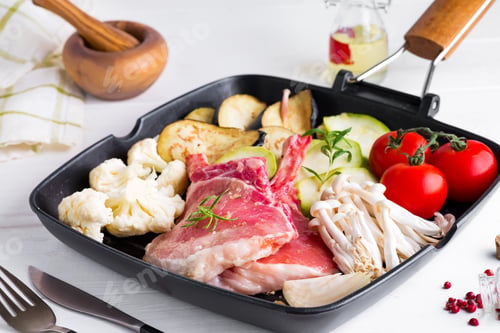 Preview: Raw lamb ribs marinating with fresh vegetables in a grill pan on a white stone background