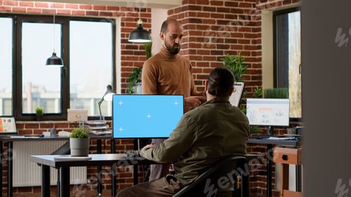 Preview: Company worker looking at greenscreen on computer