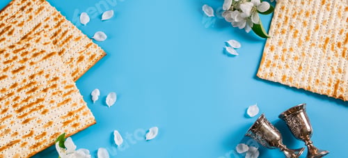 Preview: Happy passover flatlay. Metal goblet, spring flowers and traditional matzah