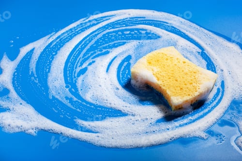 Preview: cleaning sponge wiping foam soap suds on blue background, household washing concept