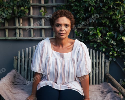 Preview: Portrait of a mature woman with short hair looking at the camera while sitting on a bench