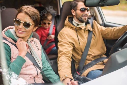 Preview: Happy friendly family travelling by car on rural road