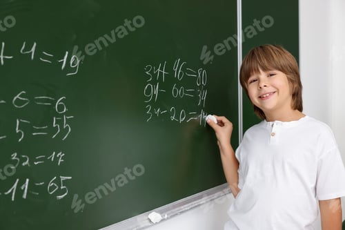 Preview: Back to school. Boy near chalkboard with math assignment indoors