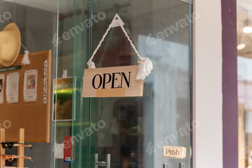 Preview: A business sign that says ‘Open’ on local businesses hang on door at entrance. Say Welcome