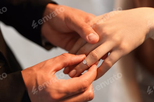 Preview: Making proposal. Man putting engagement ring on his girlfriend's finger indoors, closeup