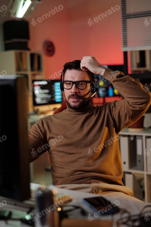 Preview: Caucasian Young Adult Man Wearing Headset Managing Scam Call Center Operations
