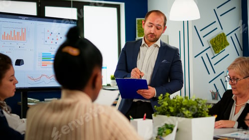 Preview: Business leader presenting company strategy to diverse team using digital whiteboard