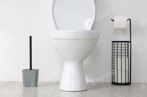 Preview: Toilet, brush and necessities near white wall