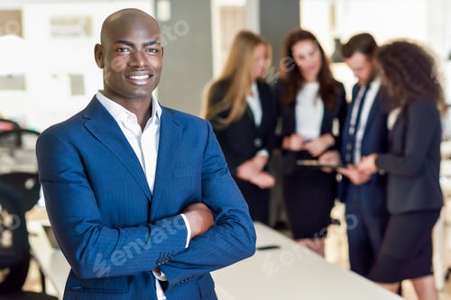 Preview: Black businessman leader looking at camera in modern office with multi-ethnic businesspeople