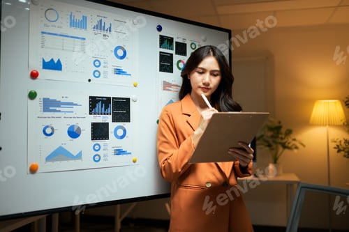 Preview: Asian businesswoman analyzing data and planning strategy in office